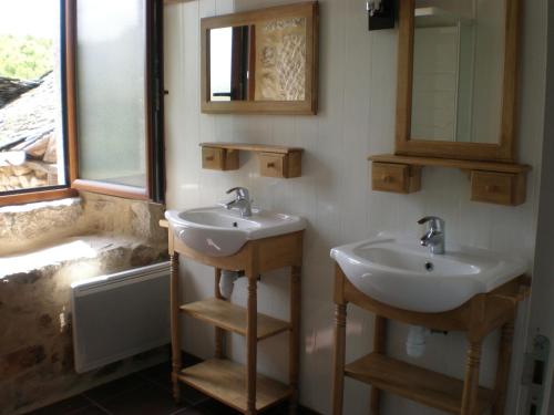 a bathroom with two sinks and a window at Gîte de la Taouyre in Saint-Symphorien-de-Thénières
