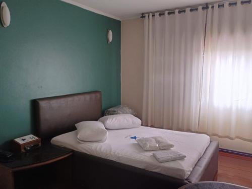 a bedroom with a bed with two pillows on it at Motel Antares in Porto Alegre