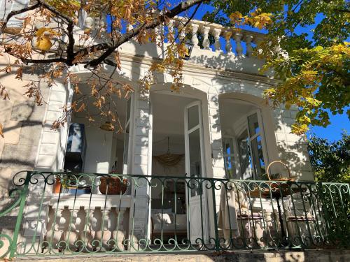 a white house with a balcony with a gate at Maison La Julianne in Callas