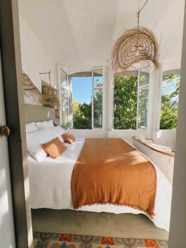 a bedroom with a large bed and windows at Maison La Julianne in Callas