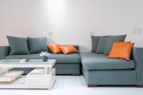 a blue couch with orange pillows and a coffee table at luxury house in Cairo