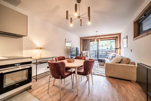 a kitchen and living room with a table and chairs at Apartment Alva Les Gets - by EMERALD STAY in Les Gets