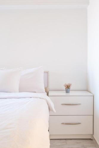 a white bedroom with a white bed and a white dresser at luxury house in Cairo