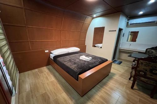 a small bedroom with a bed and a desk at Palm Cabanas Resort in Arayat