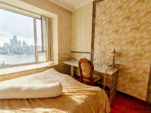 Un dormitorio con una cama y un escritorio y una ventana. en Panoramic views of the Bund and the Yangtze River, adjacent to the Oriental Pearl Tower, a top-tier luxury residence in Shanghai, en Shanghái