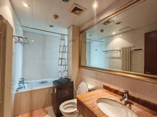 Un baño con lavabo, inodoro y espejo. en Panoramic views of the Bund and the Yangtze River, adjacent to the Oriental Pearl Tower, a top-tier luxury residence in Shanghai, en Shanghái