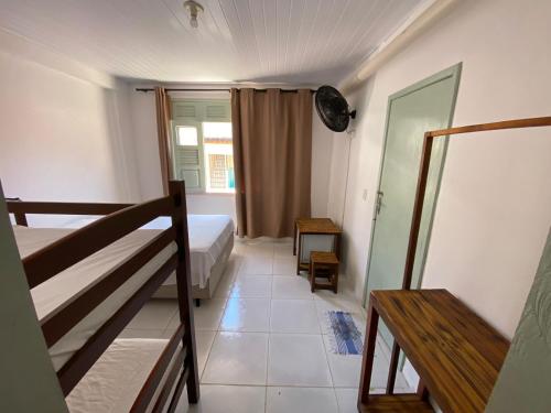 a small room with a bed and a staircase at Hospedagem Raiz Vida in Itacaré
