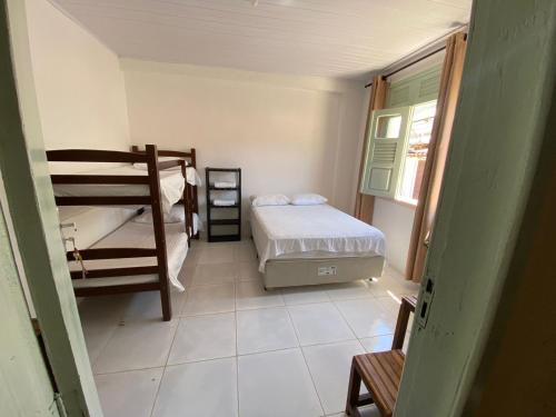 a room with a bed and a bunk bed at Hospedagem Raiz Vida in Itacaré