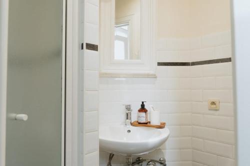 a white bathroom with a sink and a shower at Urban Hideout Just Steps from Antwerp's Highlights in Antwerp