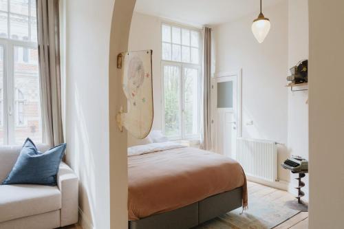 a bedroom with a bed and a couch at Urban Hideout Just Steps from Antwerp's Highlights in Antwerp