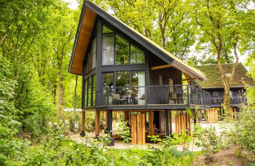 a house in the woods with large glass windows at Natuur Villa met Hottub & Sauna | 2 personen - Resort Valley in Wekerom