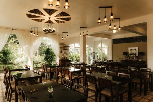 ein Restaurant mit Tischen und Stühlen in einem Raum in der Unterkunft The Premises Hotel in Dipolog City