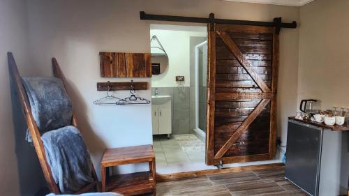 a bathroom with a sliding barn door in a room at Berlouri Guest House Family Suite in Hekpoort