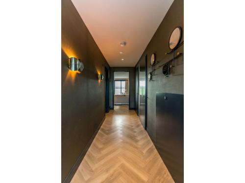 - un couloir avec des murs noirs et du parquet dans l'établissement Modern villa in De Cocksdorp near the beach, à De Cocksdorp