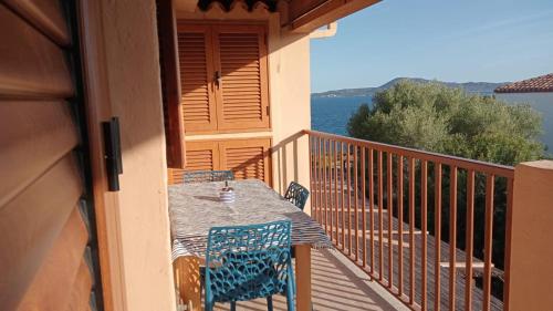 a table and chairs on a balcony with the ocean at Appartamento Pietro direttamente sul mare di costa smeralda in Olbia