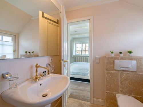 a bathroom with a sink and a mirror at Leuchtturmblick-West in Kampen