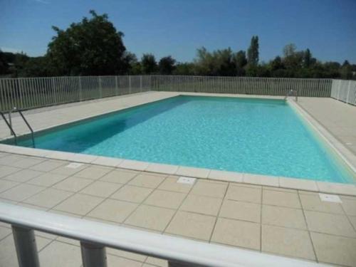 a large swimming pool with blue water at T2 Pineuilh avec parking privé in Pineuilh