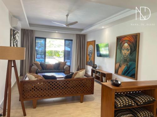 a living room with a couch and a painting on the wall at beachfront hideaway 1bed with pool&ac in Diani Beach