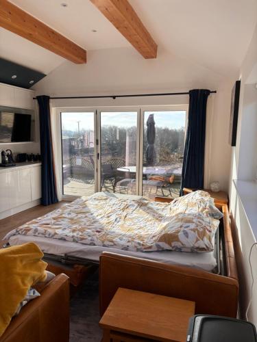 a bedroom with a bed and a large window at The Stables at Lower Carr Barn in Halifax