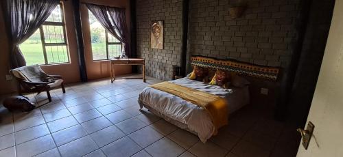 a bedroom with a bed and a brick wall at Daisy Lodge in Barberton
