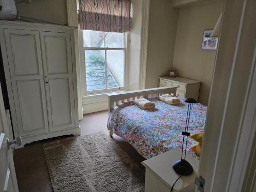 a small bedroom with a bed and a window at Seaview Apartment in Aberystwyth