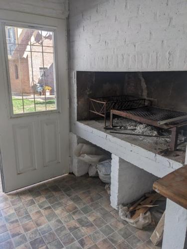 a room with a fireplace and a window and a door at La Alpina in Chivilcoy