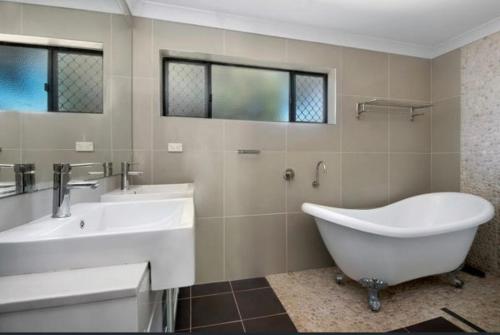 a bathroom with a tub and a sink at Scarborough Stays - Sleeps 8 by the Beachside in Scarborough