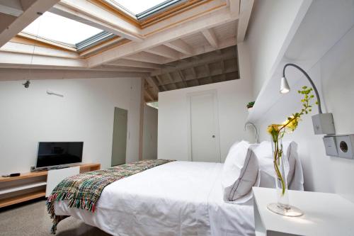 a bedroom with a white bed and a tv at Centro de Ecoturismo Tierra del Agua in Caleao