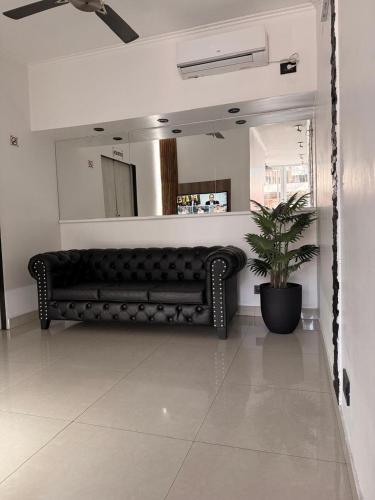 a black couch in a room with a mirror at Hotel Quito in Buenos Aires
