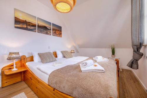 a bedroom with a large bed with towels on it at Haus Kranichwiese in Zingst