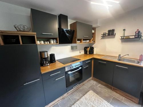 une cuisine avec des armoires grises et un évier dans l'établissement Ferienwohnung vor dem Zoller, à Boll