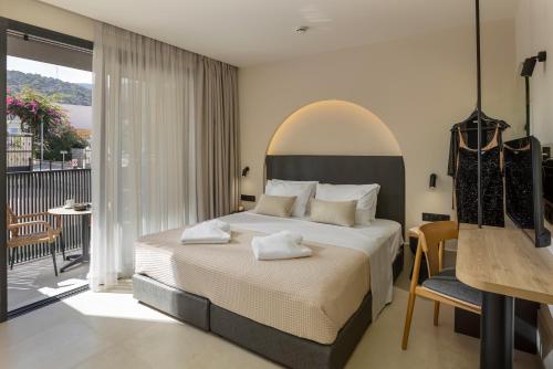a bedroom with a large bed and a balcony at Karteris Luxury Suites in Stalís