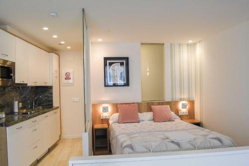 a bedroom with a bed with two pillows on it at Apartamentos Marqués de Abastos in Logroño