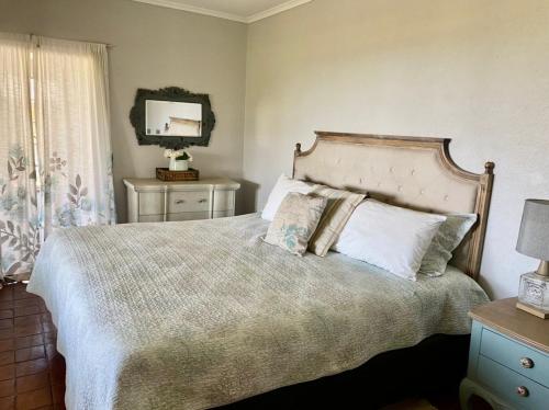 Victorian style cottage in Nyanga - 2096 في Juliasdale: غرفة نوم بها سرير كبير ومرآة