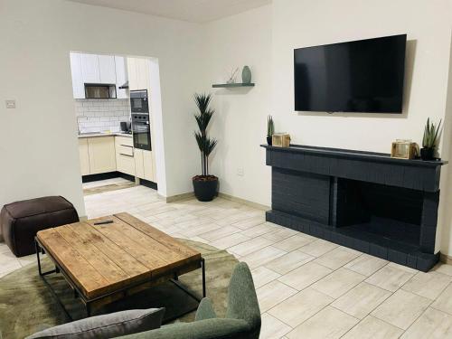 a living room with a fireplace with a flat screen tv at Canvas Lofts 1 – Famona modern 2-bed - 2310 in Bulawayo