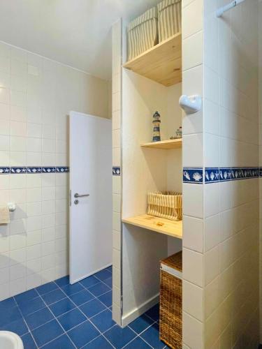 a bathroom with a white toilet and blue tiles at Pijamas House 2 in Gafanha da Encarnação