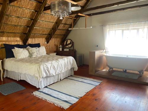 Stunning private cottage in the heart of Nyanga - 2095 في Juliasdale: غرفة نوم بسرير وحوض ونافذة