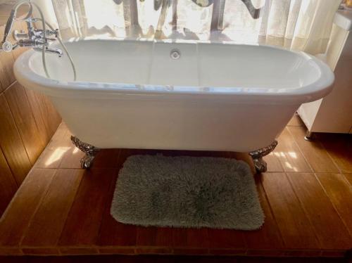 Stunning private cottage in the heart of Nyanga - 2095 في Juliasdale: حوض استحمام أبيض في حمام به نافذة