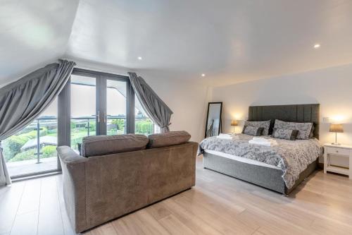 een slaapkamer met een bed en een bank bij 4 Bed in Woolacombe oc-l33535 in Mortehoe