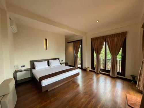 タンガラにあるMowni View - Tangalleの大きなベッドと大きな窓のある寝室