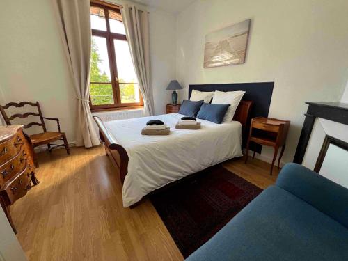 a bedroom with a large white bed with blue pillows at Maison meulière du 34e Sacre, à proximité du Domaine Pommery in Reims