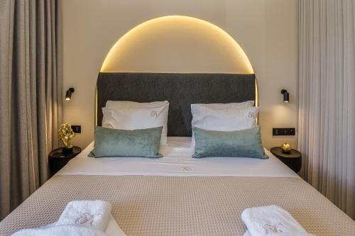 a bedroom with a large bed with a large headboard at Karteris Luxury Suites in Stalida