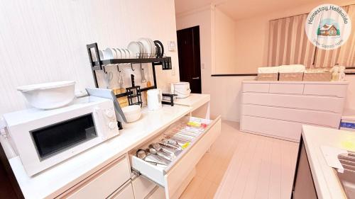 a kitchen with a microwave on top of a counter at Snow Sapporo cozy house in Sapporo