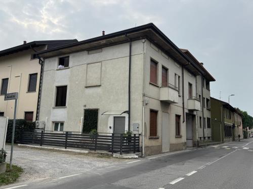an old white building on the side of a street at Brianza Home in Giussano