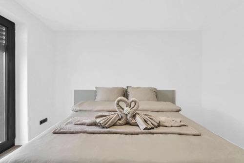 a white bed with a bow on top of it at BNB Family Living Hviezdoslavov in Hviezdoslavov