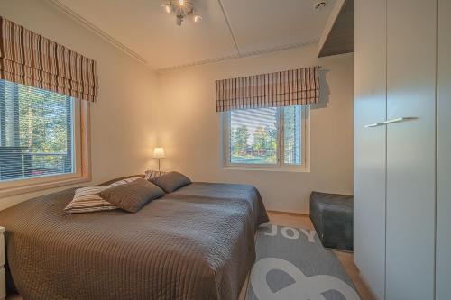 レヴィにあるLevin Stara A6 Visit Leviのベッドと2つの窓がある寝室