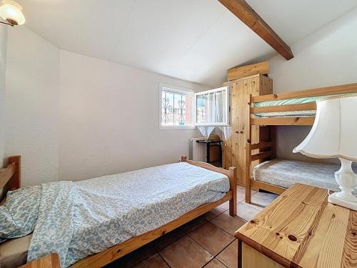 a bedroom with two bunk beds and a table at L'Ulysse - 5pers - Climatisation - plage à 200 m in Narbonne
