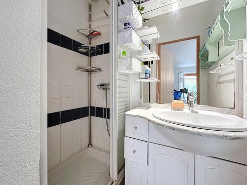 a white bathroom with a sink and a shower at L'Ulysse - 5pers - Climatisation - plage à 200 m in Narbonne