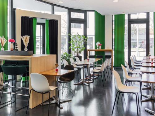 un restaurante con mesas, sillas y paredes verdes en B&B Hotel Aalen, en Aalen