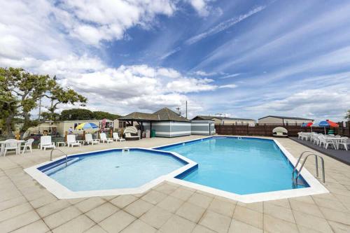 a large swimming pool on a patio with tables and chairs at 13 West Drive in Warsash